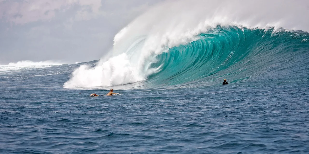 Surfer riding a powerful turquoise wave